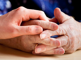Young hand touching hands of older person